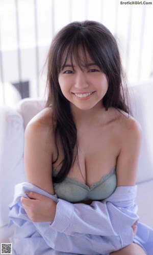 A woman in a pink bikini sitting on a wooden stool.