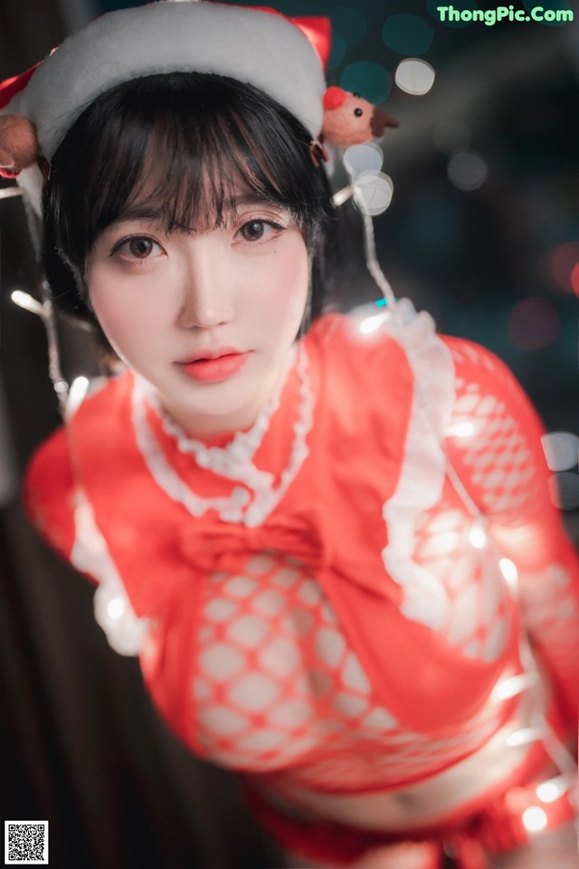 A woman in a red and white outfit with a santa hat.