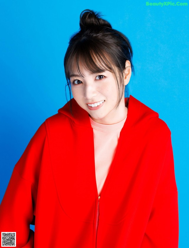 A woman in a red jacket posing for a picture.