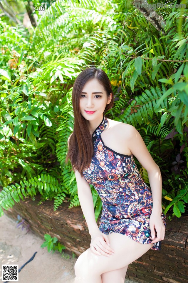 A woman in a blue and red dress posing for a picture.