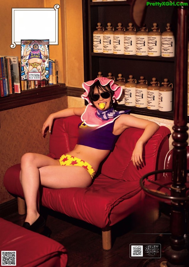 A woman sitting on a red couch in a room.