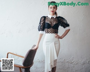 A woman in a white shirt and pink skirt standing on a staircase.