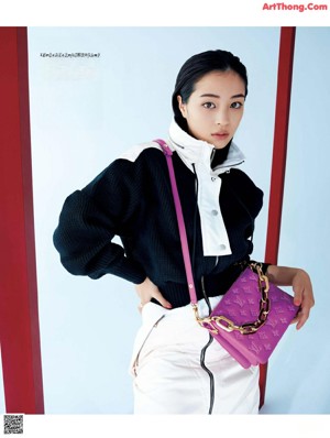 A woman in a white dress and black boots posing for a magazine.