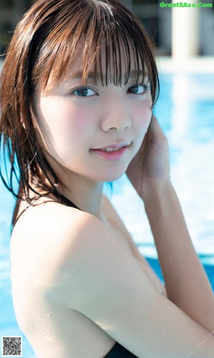 A woman in a white bikini standing next to a wooden fence.