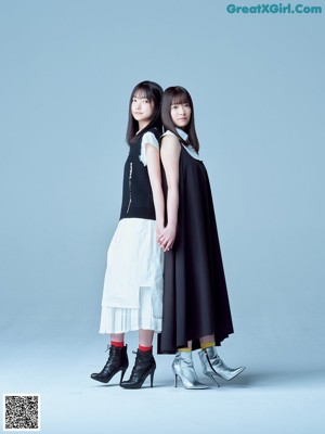 A couple of women standing next to each other on a blue background.