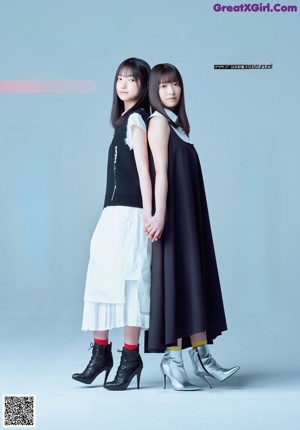 Two young women standing next to each other on a blue background.
