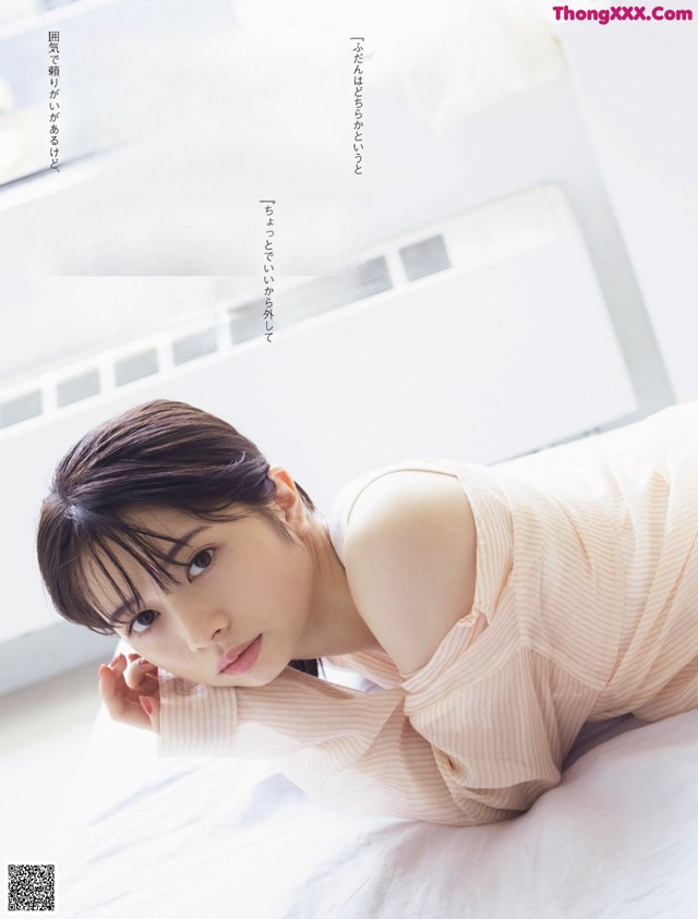 A woman laying on top of a white bed.