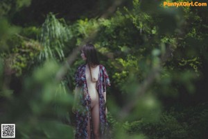 A woman standing in a field of tall grass.