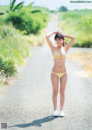 A woman in a green bikini sitting on the floor.