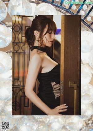 A woman in a black dress holding a glass of champagne.