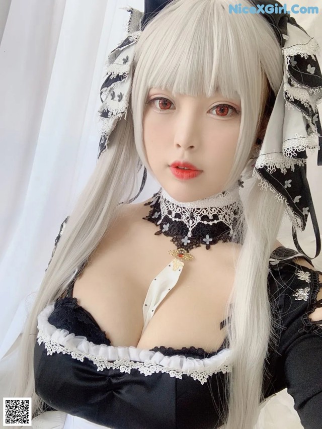 A woman with long white hair wearing a black and white dress.