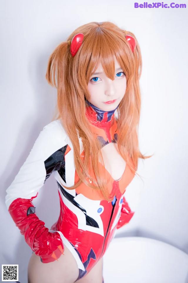 A woman in a red and white outfit posing for a picture.