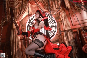 A woman in a red and black corset holding a gun.