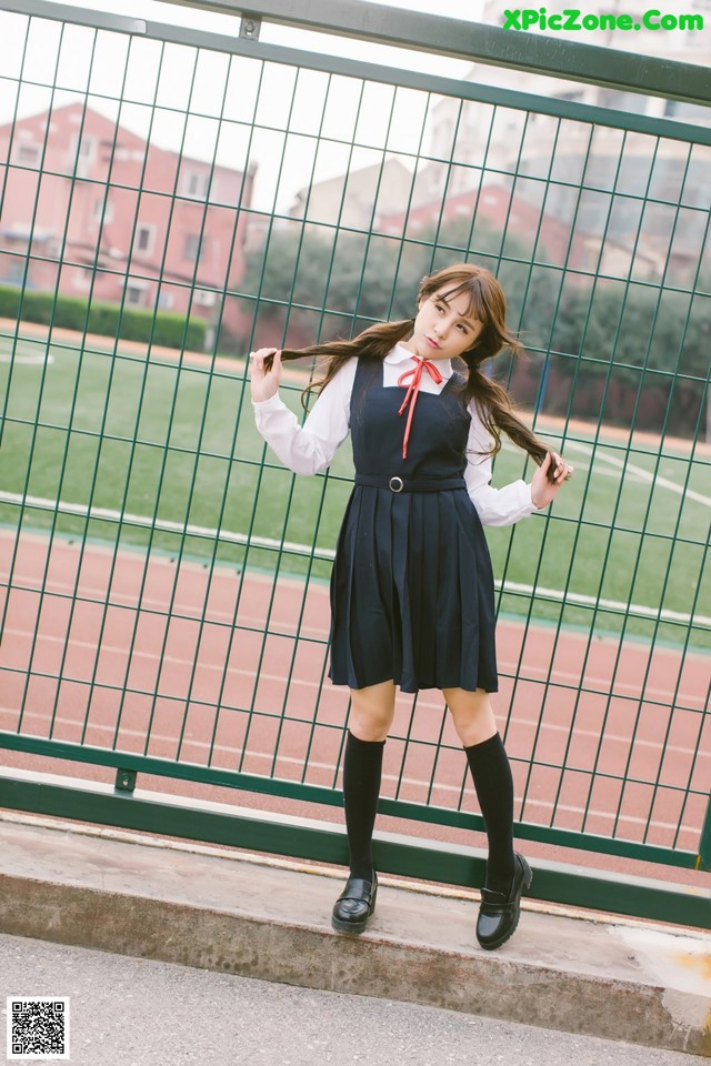 A woman in a school uniform posing for a picture.