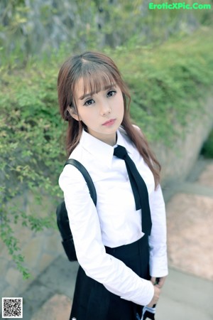 A woman in a school uniform posing for a picture.