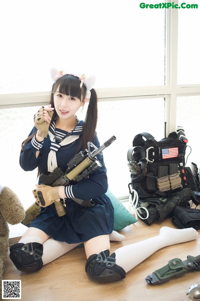 A woman in a sailor outfit holding a gun.