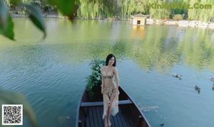 A woman in a gold bikini posing on a boat.