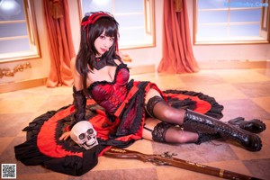 A woman in a red and black dress sitting on a staircase.