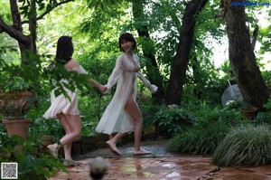 Two women standing next to each other in a garden.