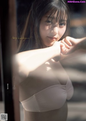 A woman in a white bra is posing for a picture.
