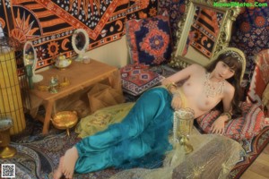 A naked woman sitting on a rug in front of a mirror.
