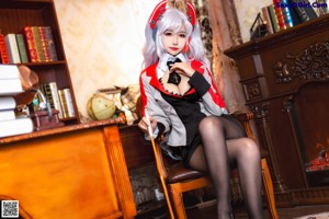 A woman sitting on top of a desk holding a wand.