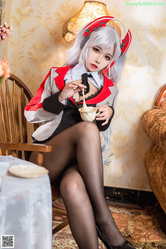 A woman sitting on a chair holding a cup of coffee.