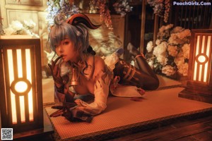 A woman with blue hair sitting on the floor next to a lamp.