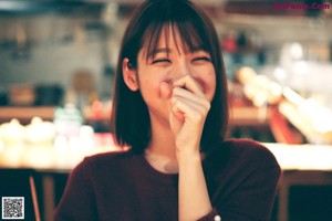 A woman eating a piece of food with chopsticks.