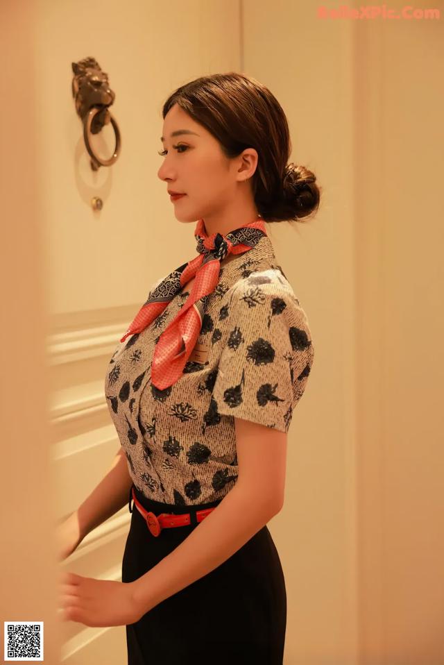 A woman in a black skirt and a red scarf.