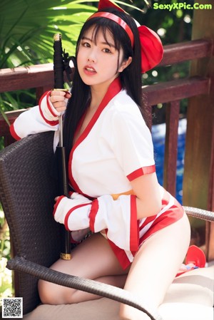 A woman in a red and white outfit sitting next to a pool.