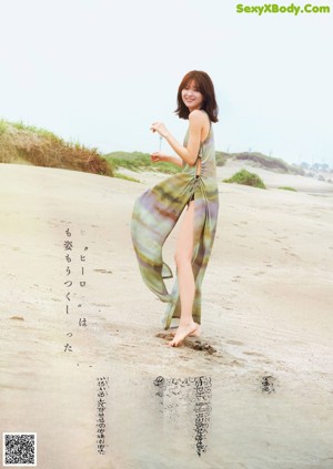 A woman with long brown hair is posing for a magazine.