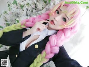 A woman with pink hair sitting on a bed of flowers.
