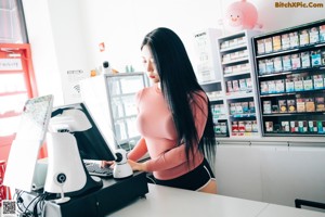 A woman in a black bra and panties sitting on a counter.