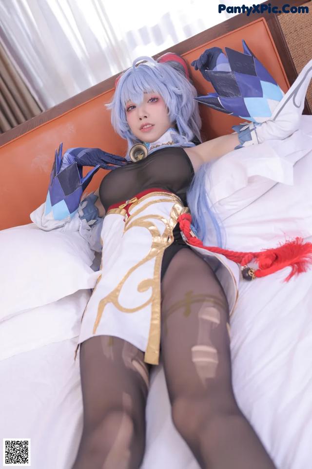 A woman in a cosplay outfit laying on a bed.