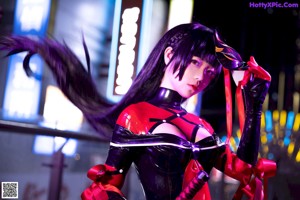 A woman in a red and black outfit holding a sword.