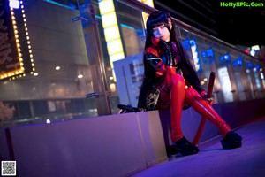 A woman in a red and black outfit is posing for a picture.