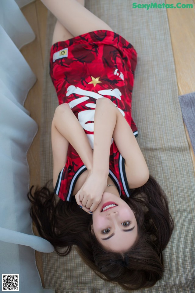 A woman laying on the floor with her legs crossed.