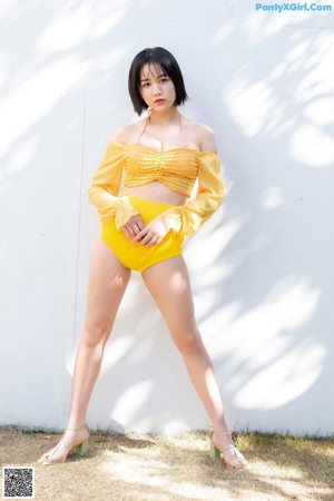 A woman in a bikini sitting on the floor.